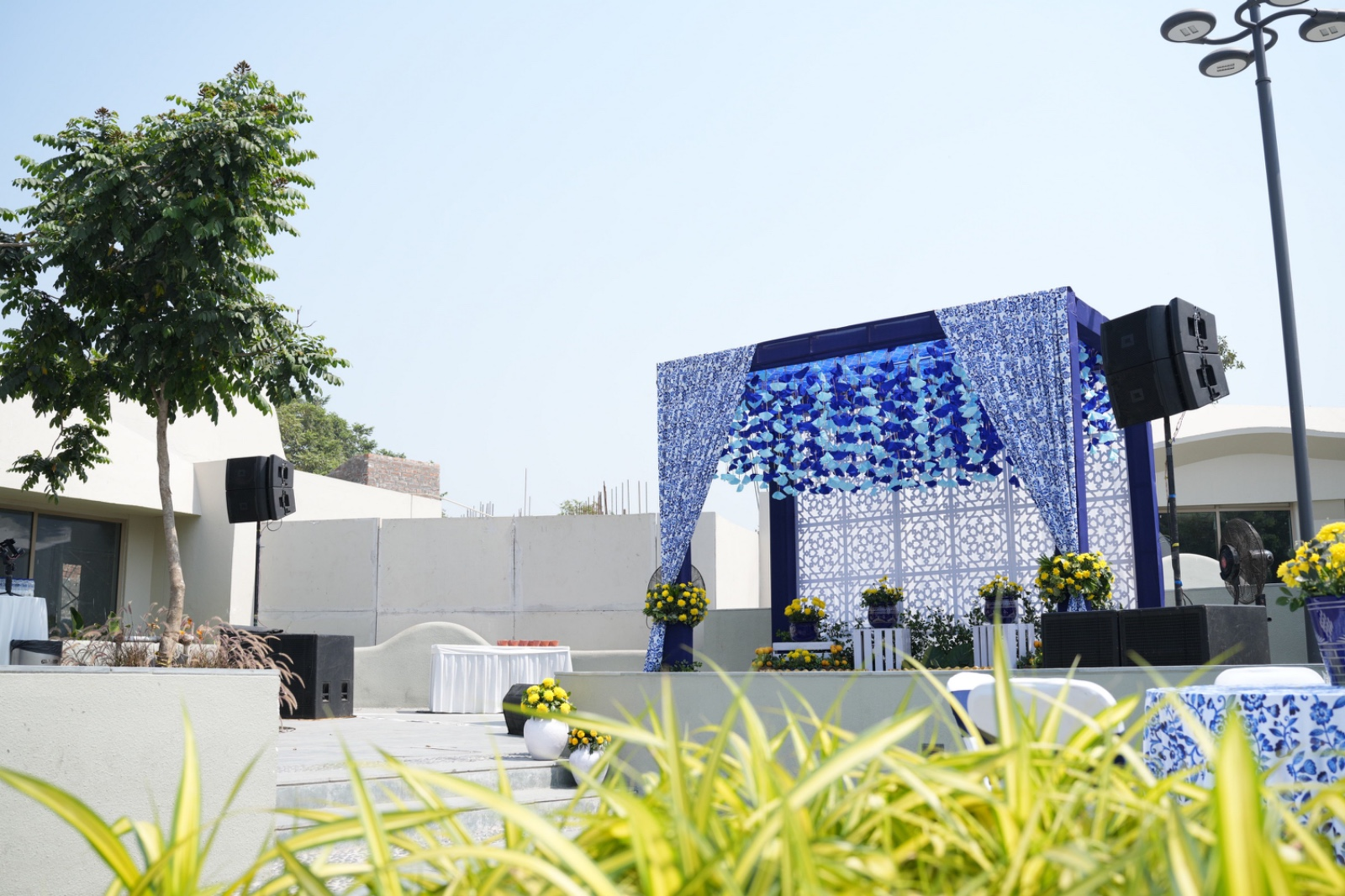 Daytime outdoor stage in blue patterned drapery with yellow floral accents